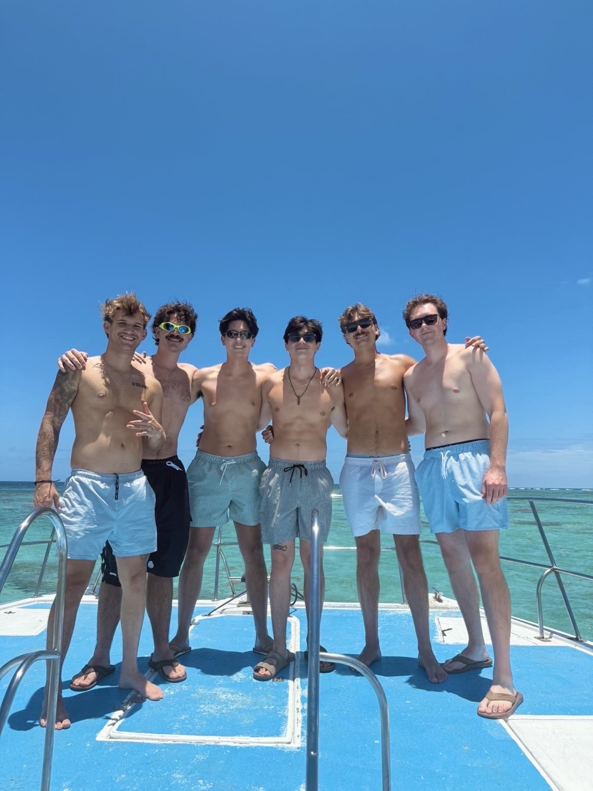 Brothers on a catamaran over turquoise water